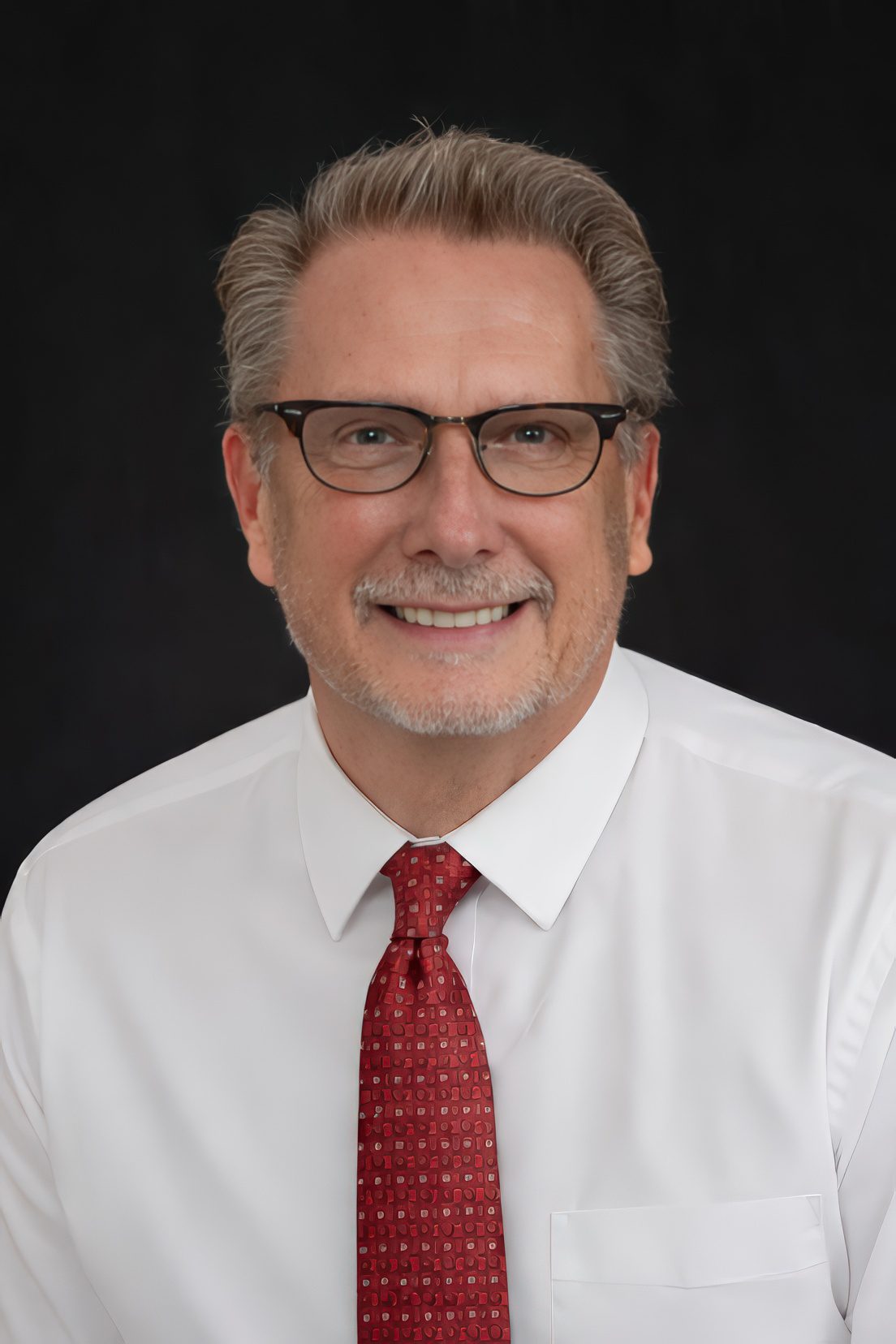 Smiling middle-aged man in glasses and tie