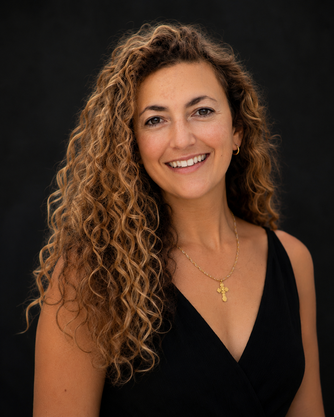 Smiling woman with long curly hair and necklace