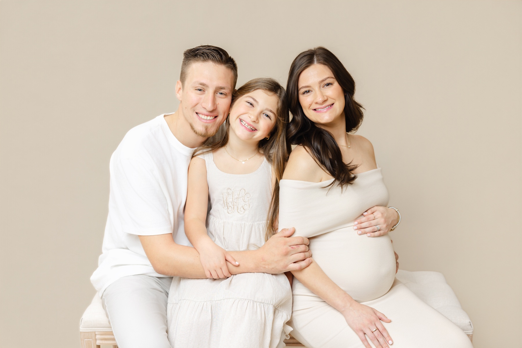 Smiling pregnant mother with husband and daughter